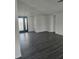 Open-concept living room with gray wood floors and large windows, with exterior door at 6241 Westport Dr, Port Richey, FL 34668