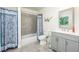 Well-lit bathroom featuring a shower and tub combination, modern fixtures, and stylish blue patterned accents at 7417 Seagull Way, Tampa, FL 33635