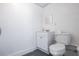 Minimalist bathroom with a clean aesthetic, featuring a toilet, sink, and mirror in a compact space at 7417 Seagull Way, Tampa, FL 33635