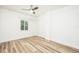 Bright, white bedroom featuring a modern ceiling fan and a large window offering plenty of natural light and new flooring at 7417 Seagull Way, Tampa, FL 33635