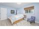 Bright bedroom with light blue walls, wood-look flooring, and a white bed frame at 7417 Seagull Way, Tampa, FL 33635