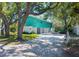 Home featuring a bright turquoise exterior, a ground-level garage, and a spacious driveway at 7417 Seagull Way, Tampa, FL 33635