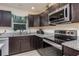 This kitchen features granite countertops, stainless steel appliances and dark wood cabinets at 7417 Seagull Way, Tampa, FL 33635