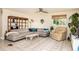 Bright living room featuring a gray sectional, ceiling fan, area rug and decorative shelving at 7417 Seagull Way, Tampa, FL 33635