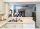 Kitchen with white cabinetry and sink featuring an opening into the bright living space at 7828 Hardwick # 923, New Port Richey, FL 34655
