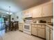 Bright kitchen with white appliances, ample cabinet space, and an adjacent dining area at 7828 Hardwick # 923, New Port Richey, FL 34655