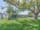 Spacious backyard with lush green grass, patio seating and a mature tree, perfect for outdoor relaxation and entertainment at 9024 140Th Way, Seminole, FL 33776