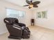 Bedroom showcasing a massage chair, with two windows providing natural light and a ceiling fan for air circulation at 9024 140Th Way, Seminole, FL 33776