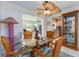 Cozy dining area featuring a glass-top table, rattan chairs, and views into the kitchen at 9024 140Th Way, Seminole, FL 33776