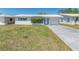 Single-story home featuring a white exterior, complemented by a well-kept lawn and mature landscaping at 9024 140Th Way, Seminole, FL 33776