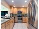 Well-lit kitchen features stainless steel appliances, granite countertops, and wooden cabinetry at 9024 140Th Way, Seminole, FL 33776
