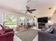 Bright living room features multiple windows, ceiling fan, tile floors, and comfortable furnishings at 9024 140Th Way, Seminole, FL 33776