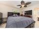 Comfortable main bedroom features a large bed, ceiling fan, and a television on a dresser at 9024 140Th Way, Seminole, FL 33776