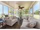 Bright sunroom with ample seating, large windows, and ceiling fan provides a cheerful space at 9024 140Th Way, Seminole, FL 33776