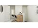 Bright hallway with a modern workspace and a glimpse into a serene bedroom at 10221 Trumpet Honeysuckle Way, San Antonio, FL 33576