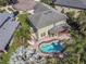 Aerial view of a spacious home featuring a pool, brick paver patio and lush landscaping at 11102 Avery Oaks Dr, Tampa, FL 33625