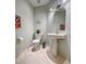 Stylish powder room with pedestal sink, decorative mirror, and modern fixtures at 11102 Avery Oaks Dr, Tampa, FL 33625