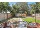 Well-maintained backyard with brick patio, stone pathway, grass, string lights and wooden fence at 1125 19Th N Ave, St Petersburg, FL 33704