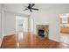 Hardwood living room featuring a stone fireplace, ceiling fan, and view into adjacent rooms at 1125 19Th N Ave, St Petersburg, FL 33704