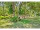 Backyard featuring lush green grass and beautiful landscaping and trees that provide both privacy and shade at 1144 Lanyard St, Palm Harbor, FL 34685