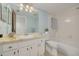 Bathroom featuring a white vanity with a light-colored countertop, a large mirror, and a white tub and shower combo at 1144 Lanyard St, Palm Harbor, FL 34685