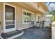 Inviting front porch featuring a welcoming seating area, plants, and tiled flooring at 1144 Lanyard St, Palm Harbor, FL 34685