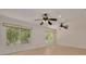 Spacious living room with dual ceiling fans and expansive windows showcasing the surrounding nature at 1144 Lanyard St, Palm Harbor, FL 34685