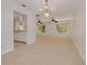 Open-concept living area with tile flooring, elegant chandeliers, and seamless flow to the kitchen at 1144 Lanyard St, Palm Harbor, FL 34685