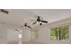 Bright living room featuring two ceiling fans and large windows overlooking lush greenery at 1144 Lanyard St, Palm Harbor, FL 34685