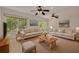 Cozy living room with comfortable sofas, a stylish rug, and views of the serene outdoors at 1144 Lanyard St, Palm Harbor, FL 34685