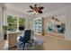 Bright office space with tile floors, a unique ceiling fan, and natural light from the glass windows and sliding door to the outside at 1144 Lanyard St, Palm Harbor, FL 34685