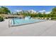 Community pool area featuring lounge chairs and a lush, tropical landscape backdrop at 1144 Lanyard St, Palm Harbor, FL 34685