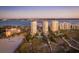 Stunning aerial view of beachfront condominiums, pools, and pristine sandy beach at sunset at 1170 Gulf Blvd # 402, Clearwater, FL 33767