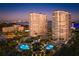 Beautiful aerial view of condo buildings with sparkling pools, lush landscaping, and beach access at 1170 Gulf Blvd # 402, Clearwater, FL 33767
