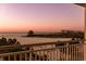 Balcony view of a wide sandy beach and calm ocean during a pastel sunset at 1170 Gulf Blvd # 402, Clearwater, FL 33767