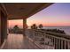 Spacious tiled balcony with views of the ocean, palm trees and a colorful sunset at 1170 Gulf Blvd # 402, Clearwater, FL 33767
