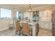 Bright kitchen with granite counters, stainless appliances, tile backsplash, and seating at the island at 1170 Gulf Blvd # 402, Clearwater, FL 33767