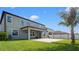 Large backyard with a lawn, patio and palm trees at 11720 Navajo Sandstone St, Riverview, FL 33579