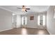 Cozy bedroom with two windows, hardwood floors, ceiling fan, and neutral color palette at 11720 Navajo Sandstone St, Riverview, FL 33579