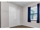 Neutral bedroom featuring closet, window with blinds and curtains and wood-look flooring at 11720 Navajo Sandstone St, Riverview, FL 33579
