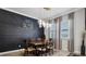Dining room features a dining table, dark accent wall, modern lighting, and neutral curtains at 11720 Navajo Sandstone St, Riverview, FL 33579