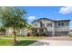 Charming two-story home featuring a brick driveway, two-car garage, and lush landscaping at 11720 Navajo Sandstone St, Riverview, FL 33579