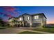 Dusk view of a beautiful two-story home with a well-manicured lawn and a brick driveway at 11720 Navajo Sandstone St, Riverview, FL 33579