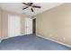 Bedroom with neutral carpet, ceiling fan, and closet space at 11780 Linden Dr, Spring Hill, FL 34608