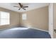 Bedroom featuring carpeted floors, a ceiling fan, and two windows for natural light at 11780 Linden Dr, Spring Hill, FL 34608
