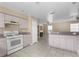 Bright kitchen with ample counter space, white appliances, and adjacent living area featuring a fireplace at 11780 Linden Dr, Spring Hill, FL 34608