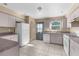 Functional kitchen with white appliances, neutral countertops and cabinets, and a practical tile floor at 11780 Linden Dr, Spring Hill, FL 34608