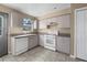 Well-lit kitchen with matching white appliances, tile flooring, and generous countertop space at 11780 Linden Dr, Spring Hill, FL 34608
