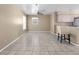 Open-concept living room with tile flooring, ceiling fan, and breakfast bar at 11780 Linden Dr, Spring Hill, FL 34608