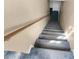 Carpeted staircase featuring a wooden handrail and neutral-colored walls provides access to the home's lower level at 11780 Linden Dr, Spring Hill, FL 34608